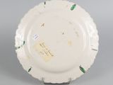 underside view of a white plate with green leaves on it