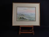 framed painting of a mountain landscape with a pink sky in the background