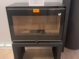 une petite armoire noire avec une porte vitrée, à côté d'un grand vase noir