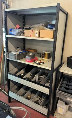 une étagère sur laquelle sont posés de nombreux outils, dans une pièce