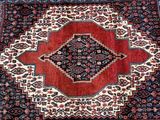 a red and blue rug with a diamond design on it