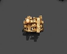 une bague en or ornée d'un train, posée sur un fond noir