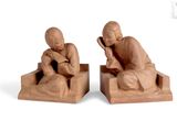 two figurines of a man and a woman sitting on a bench