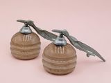 pair of antique salt and pepper shakers on a pink background