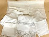 plusieurs pièces de linge blanc ornées de dentelle, posées sur une table