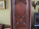 une grande armoire en bois dans un coin du salon