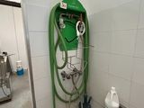 un tuyau vert fixé au mur d'une salle de bains