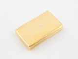 an image of a gold cigarette case on a white surface