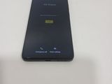 the back of a black cell phone sitting on top of a white table