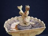 a bird that is sitting in a bowl on a table