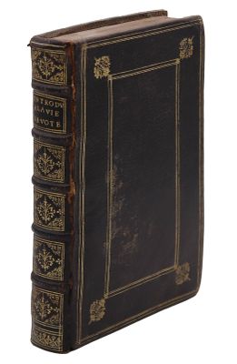 un vieux livre à la couverture noire, avec des bordures dorées sur fond blanc