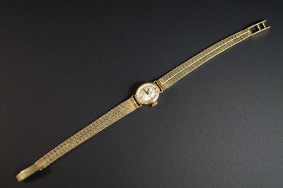 gros plan d'une montre sur une surface noire avec un fond noir