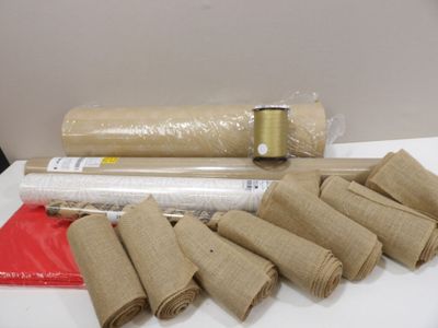 plusieurs rouleaux de papier kraft posés sur une table, à côté d'un rouleau de ruban adhésif