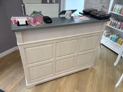 an image of a salon counter with a lot of products on it
