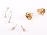three pairs of earrings and a chain on a white surface