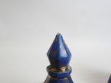 two blue vases sitting on a table with a white background