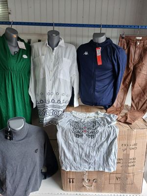 several mannequins are lined up in a room with clothing on display