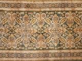 un tapis ancien avec un motif floral sur fond blanc