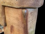 a close up of a clay vase with a black background
