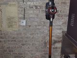 an image of a room with a vacuum and a surfboard on the wall
