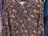 a woman ' s blouse hanging on a rack in a clothing store