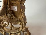 a gold clock sitting on top of a white table