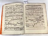 an open book with music notes on it sitting on a table