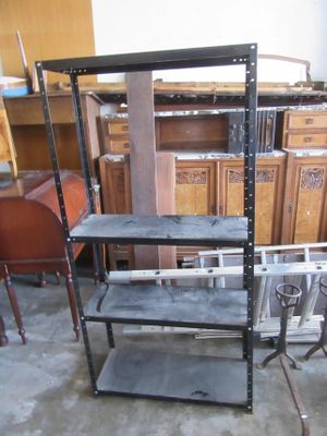une étagère métallique comportant plusieurs tablettes, dans une pièce
