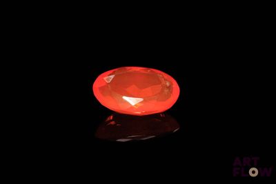 a close up of a red diamond on a black surface