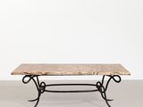 une table avec un plateau en marbre et des pieds en fer