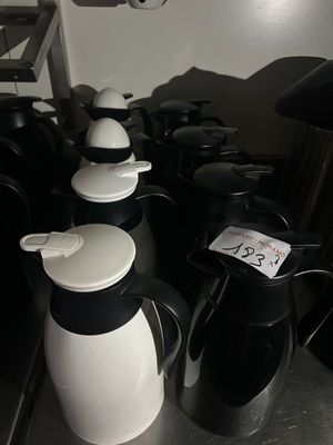 many black and white coffee pots sitting on a table