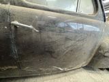 a old car that has been painted black in a garage