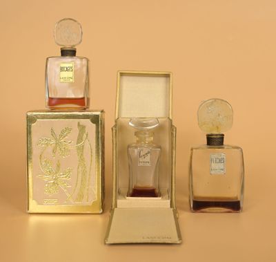 three bottles of perfume sitting next to each other on top of a table