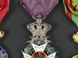 three medals are displayed on a black surface with a red ribbon