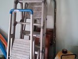 a ladder that is leaning against a wall next to a chair