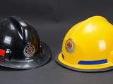 two firemen hats sitting next to each other on a table