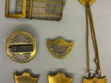 quelques objets en métal doré sont posés sur une surface blanche