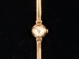 an image of a close up of a wrist watch on a black surface