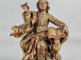 l'image d'une statue de femme assise sur un rocher