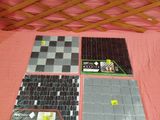 quatre carreaux de faïence posés sur un lit recouvert d'une couverture rose