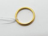 gros plan d'une bague en or sur une surface blanche