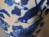 a blue and white vase with a bird on it