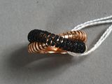 une photo d'une bague noire et dorée suspendue à un cordon