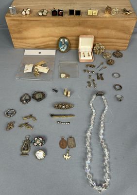 une boîte en bois remplie de bijoux variés posée sur une table