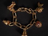 un gros plan d'un bracelet en or orné de breloques sur fond noir