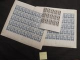 two sheets of blue and white stamps on a black cloth