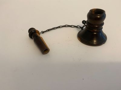 an old brass candle holder with a chain attached to it