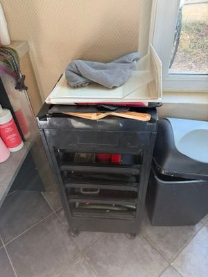 a black trash can next to a toilet in a bathroom