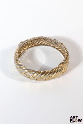 YVES SAINT LAURENT Bracelet jonc tressé en métal doré Signé.