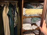 a person that is looking at a closet full of clothes
